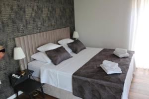a bedroom with a large bed with white sheets and pillows at Apartments Marvi Ugljan in Ugljan