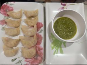 a plate of food with a bowl of dipping sauce at Vigyan Guest House Tosh in Tosh