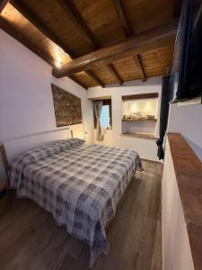 a bedroom with a bed with a checkered blanket at Dimora nel borgo in Bibbiena