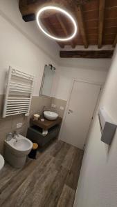 a bathroom with a sink and a toilet and a mirror at Dimora nel borgo in Bibbiena +22 photos