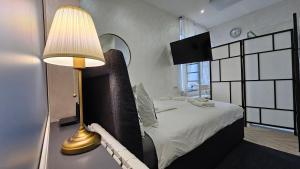 ein Schlafzimmer mit einem Bett und einer Lampe auf einem Tisch in der Unterkunft Teeny tiny in Šentvid