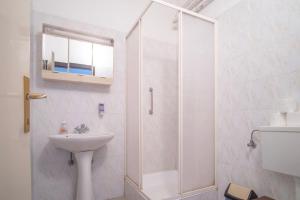 a white bathroom with a sink and a shower at Sirály in Balatonlelle +20 photos
