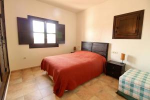 Un dormitorio con una cama roja y una ventana. en HL 007 Holiday Rentals 3 bedroom 2 bathroom villa, en Corverica