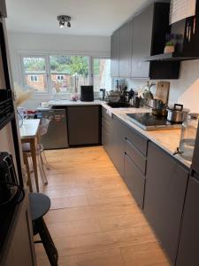 a kitchen with a wooden floor and a counter top at Cozy Double Room in North London with Great Transport Links in Brimsdown Station +4 photos