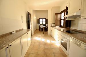 Una cocina con gabinetes blancos y una mesa en ella. en HL 007 Holiday Rentals 3 bedroom 2 bathroom villa, en Corverica