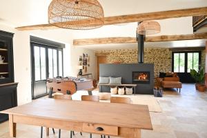 a living room with a table and a fireplace at La Grange et le Nid in Saint-Pierre-des-Nids