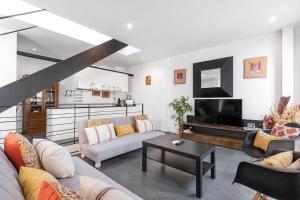 Una sala de estar con un sofá y un televisor. en LovelyLoft Navíos, en Alicante