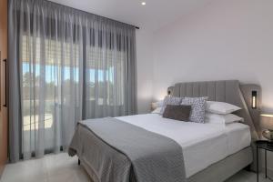 a bedroom with a bed and a large window at Villa Galini in Haraki