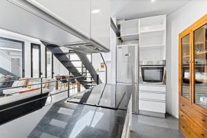 cocina con encimera de cristal y escalera en LovelyLoft Navíos, en Alicante