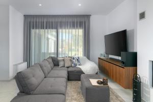 a living room with a couch and a flat screen tv at Villa Galini in Haraki