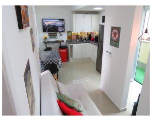 un soggiorno con un divano bianco e una cucina di Apartamentos com 2 quartos Praia de Itapema a Itapema