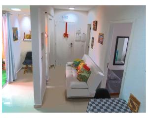 un soggiorno con divano bianco e un corridoio di Apartamentos com 2 quartos Praia de Itapema a Itapema