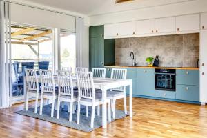 a kitchen with a white table and white chairs at Visby Villas in Visby
