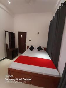 a bedroom with a large bed with a red blanket at Trinco Harbour Villa in Trincomalee