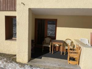 a patio with a table and chairs in a building at appartement au pied des pistes in Valmorel +6 photos