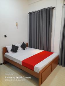 Un dormitorio con una cama con una manta roja y blanca. en Trinco Harbour Villa, en Trincomalee