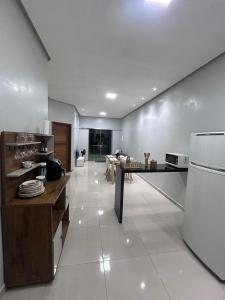 a kitchen with a table and a refrigerator at Apartamento em Alter do chão 2 quartos in Santarém +7 photos