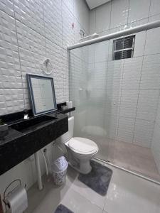 a bathroom with a toilet and a computer on a counter at Apartamento em Alter do chão 2 quartos in Santarém
