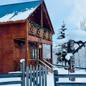 een houten hut met een hek in de sneeuw bij Hill SilENCE MESTIA 1 in Mestia