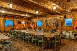 een grote tafel en stoelen in een kamer met houten wanden bij Pater Noster A home on the horizon in Hamneskär