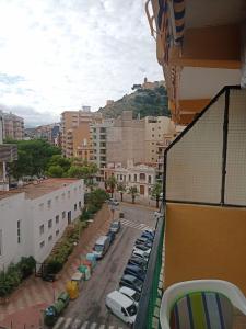 Una vista de una ciudad con coches aparcados en una calle. en Cullera Marisa, en Cullera