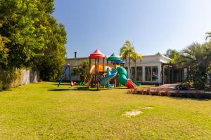 ein Spielplatz in einem Hof neben einem Haus in der Unterkunft Casa Completa Condomínio Rosa Internacional - ao lado Sufland - Garopaba-SC in Garopaba