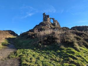 a castle on top of a hill with a dirt road at Cosy Country Styled Apartment in Kidsgrove