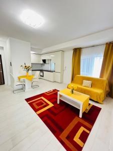 Una sala de estar con una cama amarilla y una alfombra roja. en Chic city home, en Timisoara