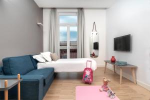 a hotel room with a bed and a child sitting on a rug at Hotel Piazza Bellini & Apartments in Naples