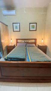un letto in legno con due luci su due comodini di Pool and Fun in Gozo, Great place to relax and enjoy nature a Għajn il-Kbira