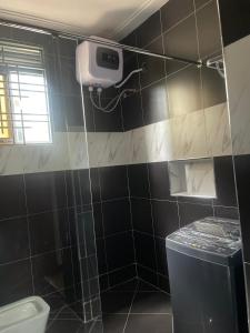a bathroom with a black and white tiled wall at Bahai temple view unlimited internet and Wi-Fi in Kampala