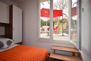a bedroom with a bed and a window with a red umbrella at Castello Rezidence Korcula in Korčula