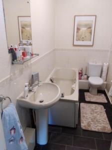 a bathroom with a sink and a tub and a toilet at Seaview Smuggler Cove Cleethoropes in Cleethorpes +43 photos