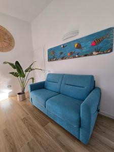 a blue couch in a living room with a painting at Holiday House in Villa Beatrice in Porto Istana