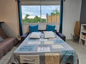 a room with a table with a couch and a window at Les hauts de beline Salines in Le Gosier
