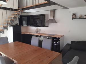 a kitchen with a wooden table and a dining room at Chez Polo in Saint-Denis