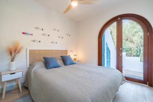 a bedroom with a bed and a large window at Casa Tuna - Beach 100m - Cala Llombards in Santanyi