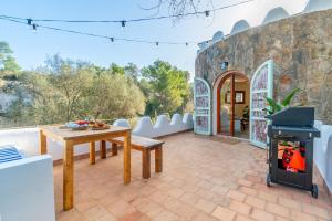 a patio with a table and a wood stove at Casa Tuna - Beach 100m - Cala Llombards in Santanyi +5 photos