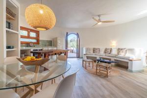a kitchen and living room with a glass table and chairs at Casa Tuna - Beach 100m - Cala Llombards in Santanyi