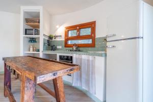 a kitchen with a wooden table and a refrigerator at Casa Tuna - Beach 100m - Cala Llombards in Santanyi