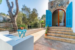 a house with blue trim and stairs and a table at Casa Tuna - Beach 100m - Cala Llombards in Santanyi