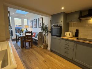 Una cocina con una mesa y un comedor. en Driftwood House - Luxury Dog-Friendly Townhouse in Cowes, Steps from Marina, en Cowes