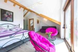 a bedroom with pink chairs and a bed at Peaceful Villa near Dubrovnik in Trsteno