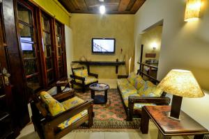 uma sala de estar com um sofá e uma mesa em Estalagem Casa Grande Pousada em Ubatuba