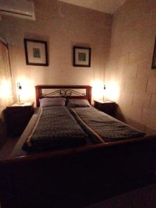 una camera da letto con un letto con due lampade sopra di Pool and Fun in Gozo, Great place to relax and enjoy nature a Għajn il-Kbira