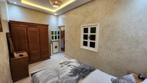 a bedroom with a bed and a wall with windows at Quadra Sphere in Tamraght Ouzdar