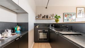 une cuisine avec des armoires noires et un comptoir dans l'établissement APPARTEMENT avec vue sur la Seine 10' en voiture de Paris et de la Tour Eiffel, à Boulogne-Billancourt 2 autres photos
