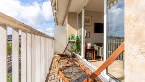 d'un balcon avec une chaise et une vue sur la ville. dans l'établissement APPARTEMENT avec vue sur la Seine 10' en voiture de Paris et de la Tour Eiffel, à Boulogne-Billancourt