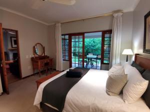 una camera da letto con un grande letto bianco e un balcone di Gracie's Cottage a Clarens
