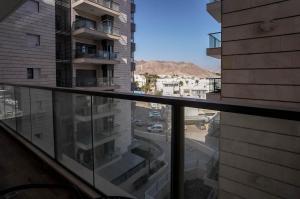a glass balcony with a view of a city at Red Sea Harmony - by G&P Suites in Eilat